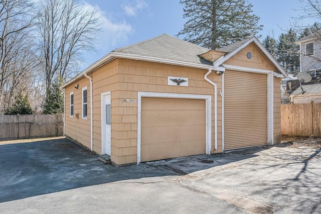 detached garage featuring fence