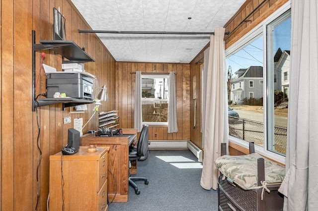 home office with wooden walls, carpet, and baseboard heating