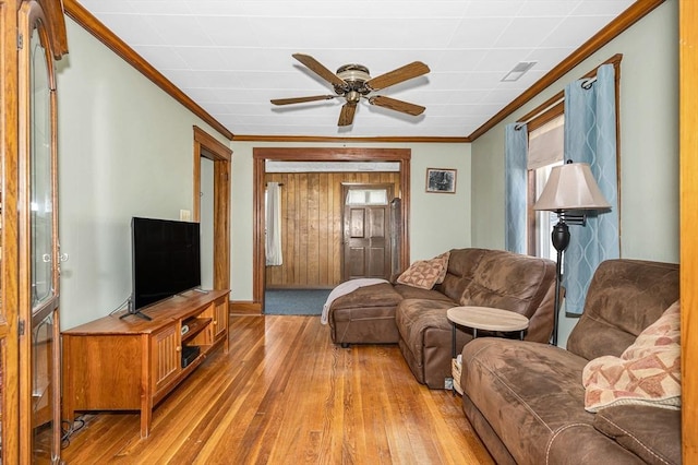 living room featuring hardwood / wood-style floors, a healthy amount of sunlight, ornamental molding, and a ceiling fan