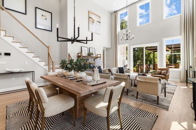 28 Juniper Ln Unit 63, Tyngsborough, MA 01879 - dining area featuring a high ceiling, light wood-type flooring, a chandelier, stairway, and baseboards
