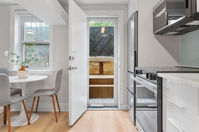 12 Fayette Unit B, Boston, MA 02116 - kitchen featuring appliances with stainless steel finishes, light wood finished floors, and baseboards