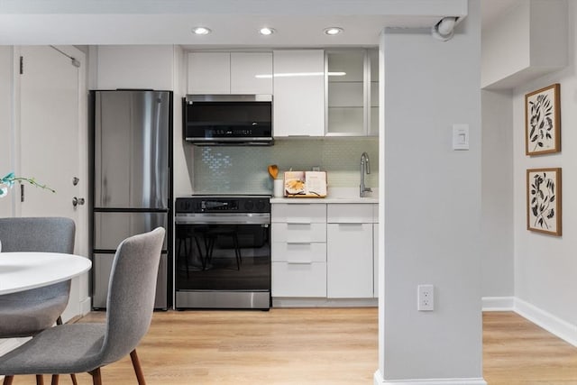12 Fayette Unit B, Boston, MA 02116 - kitchen with appliances with stainless steel finishes, white cabinets, a sink, backsplash, and light wood finished floors