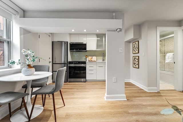 12 Fayette Unit B, Boston, MA 02116 - kitchen featuring stainless steel appliances, white cabinetry, decorative backsplash, light wood finished floors, and baseboards