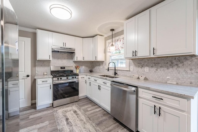70 Ferncroft St, Longmeadow, MA 01106 - kitchen with stainless steel appliances, under cabinet range hood, white cabinetry, light wood finished floors, and ornamental molding