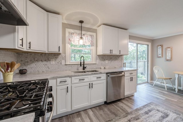 70 Ferncroft St, Longmeadow, MA 01106 - kitchen with stainless steel appliances, under cabinet range hood, light wood finished floors, tasteful backsplash, and white cabinets