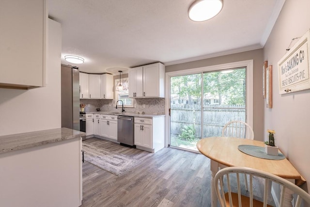 70 Ferncroft St, Longmeadow, MA 01106 - kitchen featuring stainless steel appliances, white cabinetry, tasteful backsplash, light wood finished floors, and crown molding