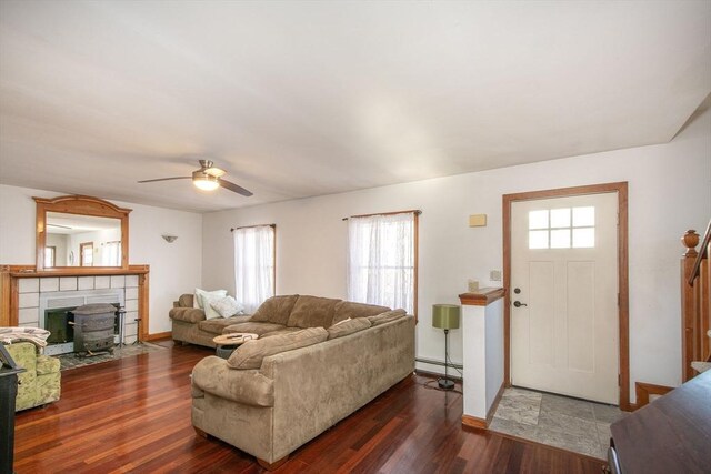 living room featuring plenty of natural light, ceiling fan, wood finished floors, and baseboard heating