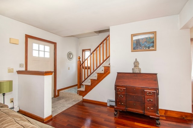 foyer entrance with dark wood-type flooring and a baseboard heating unit