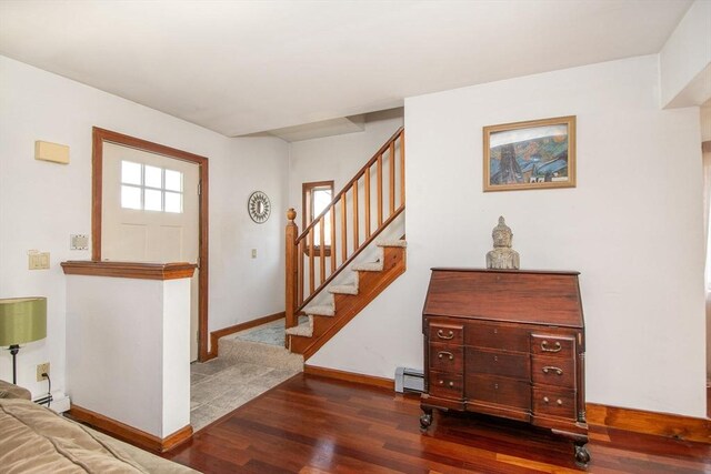 foyer with baseboards, wood finished floors, stairway, and a baseboard radiator