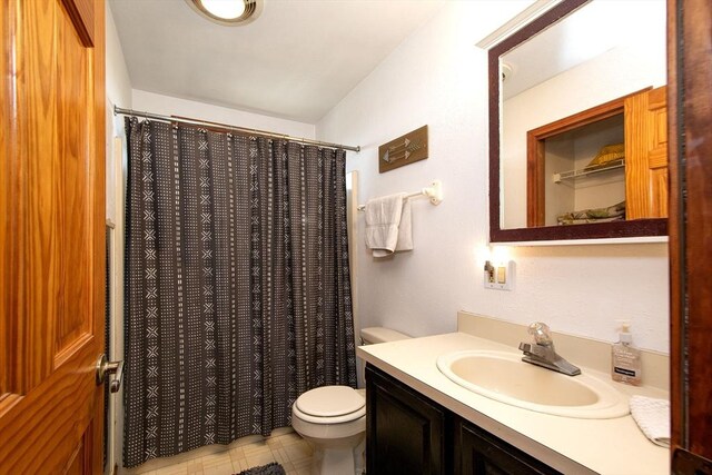 bathroom with vanity, curtained shower, and toilet
