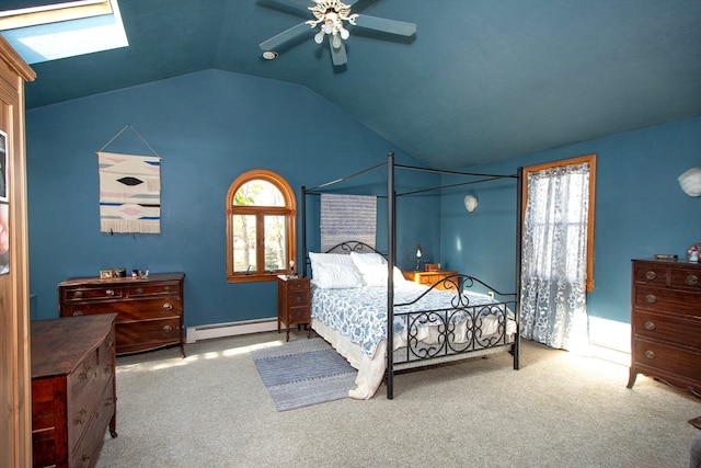 bedroom featuring ceiling fan, vaulted ceiling with skylight, baseboard heating, and light colored carpet