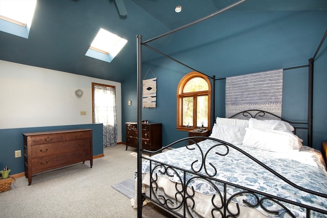 bedroom featuring carpet, multiple windows, high vaulted ceiling, and a skylight