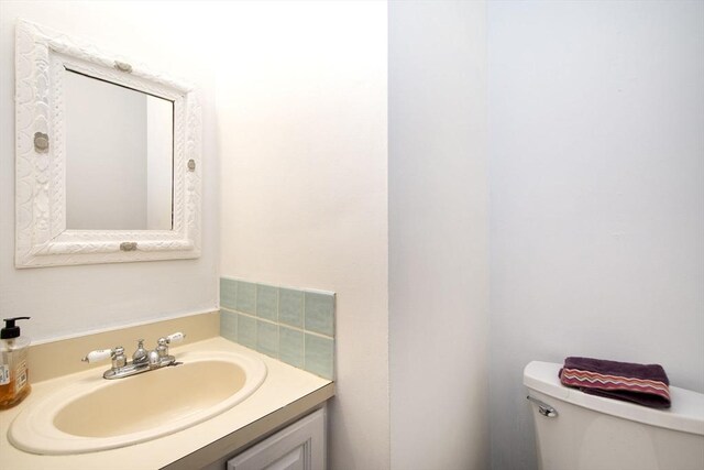 half bathroom featuring toilet and vanity