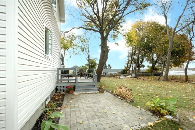view of patio with a wooden deck and fence