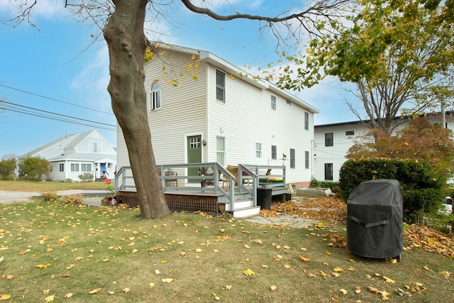 back of property with a wooden deck and a lawn