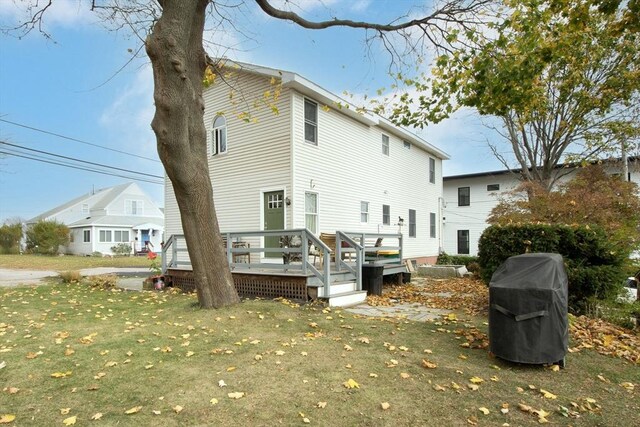 back of house with a wooden deck and a yard