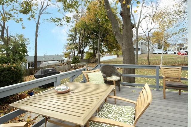 deck featuring fence, a residential view, and outdoor dining space
