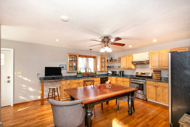 kitchen with light hardwood / wood-style floors, stainless steel appliances, sink, and decorative light fixtures