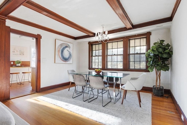 dining room with crown molding, a chandelier, light hardwood / wood-style flooring, and beamed ceiling