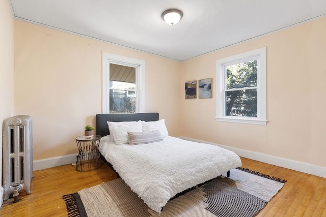 bedroom with wood-type flooring and radiator