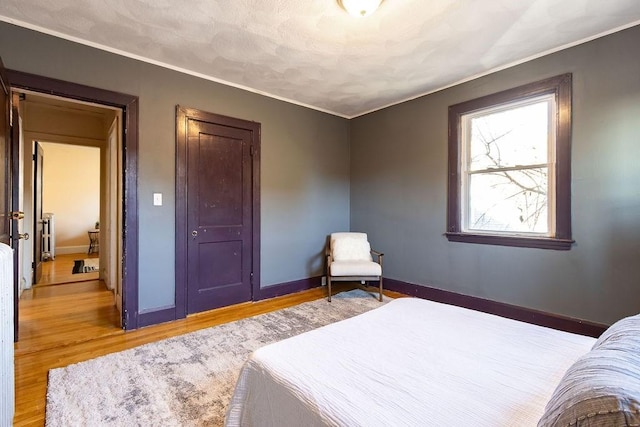 bedroom with hardwood / wood-style flooring and crown molding