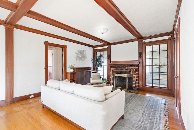 unfurnished living room featuring light hardwood / wood-style floors, beamed ceiling, and plenty of natural light