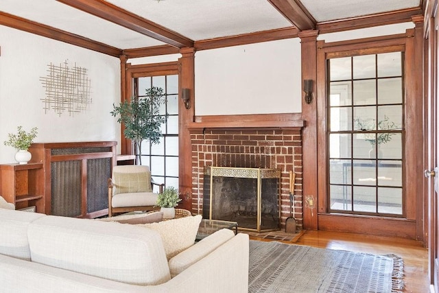 living room featuring light wood-type flooring, beamed ceiling, and a brick fireplace