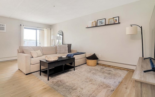 157 Franklin St Unit D3, Stoneham, MA 02180 - living area featuring a baseboard radiator, wood finished floors, and an AC wall unit
