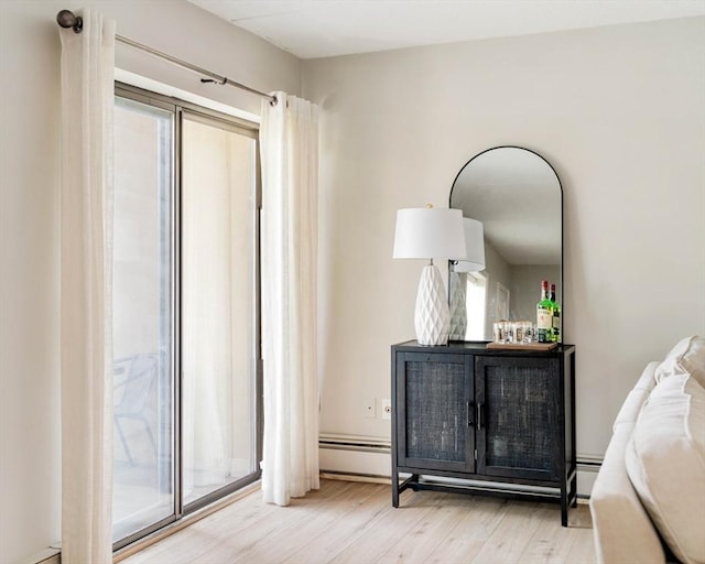 157 Franklin St Unit D3, Stoneham, MA 02180 - bedroom featuring wood finished floors, a baseboard radiator, and a bar