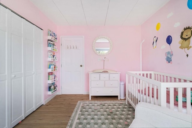 157 Franklin St Unit D3, Stoneham, MA 02180 - bedroom featuring wood finished floors, a crib, and a closet