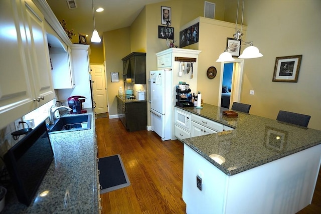 895 Dennison Dr, Southbridge, MA 01550 - kitchen with white appliances, a peninsula, dark wood-style flooring, white cabinets, and pendant lighting