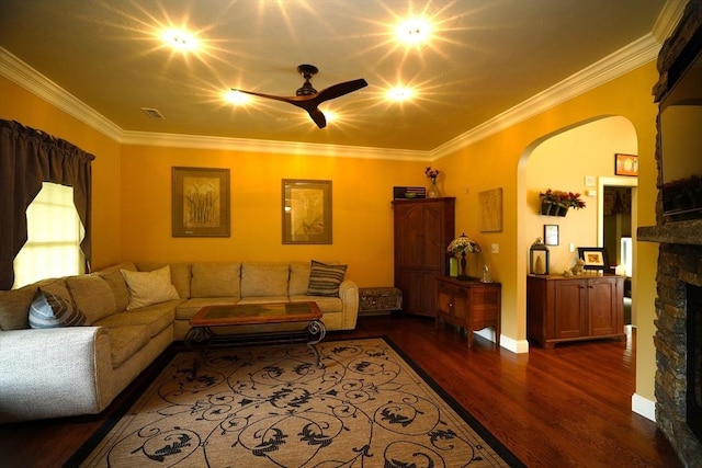 895 Dennison Dr, Southbridge, MA 01550 - living room with arched walkways, a stone fireplace, dark wood-type flooring, crown molding, and a ceiling fan