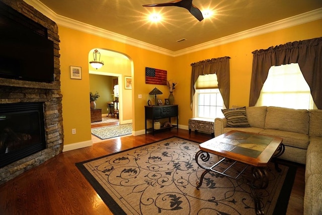 895 Dennison Dr, Southbridge, MA 01550 - living room with arched walkways, ceiling fan, ornamental molding, a stone fireplace, and wood finished floors