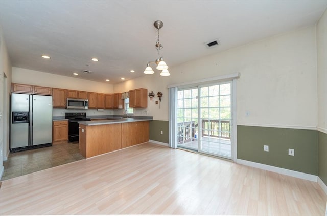 1 Knotts St Unit 1, Hudson, MA 01749 - kitchen featuring fridge with ice dispenser, black range with electric cooktop, stainless steel microwave, baseboards, and brown cabinetry