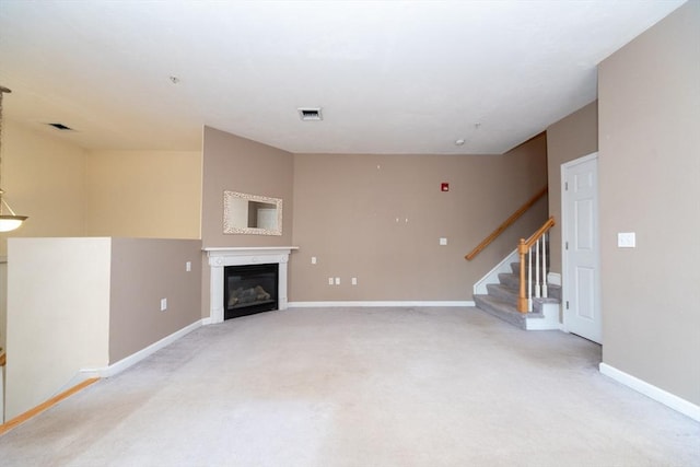 1 Knotts St Unit 1, Hudson, MA 01749 - unfurnished living room with light colored carpet, stairway, baseboards, and a glass covered fireplace