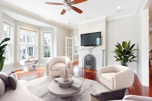 living room with ornamental molding, hardwood / wood-style flooring, and ceiling fan