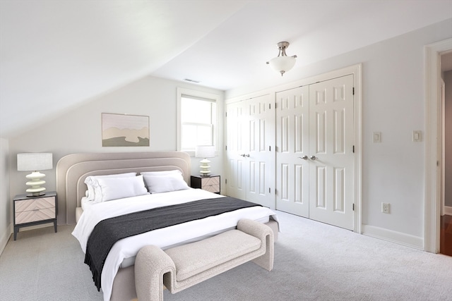 carpeted bedroom with multiple closets and lofted ceiling