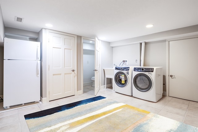 washroom with washer and dryer and light tile patterned floors