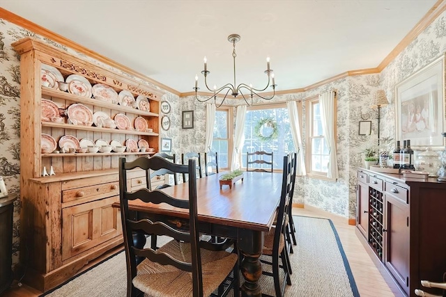 dining space with wallpapered walls, crown molding, and an inviting chandelier