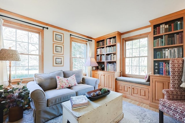 living room with a wealth of natural light, light wood-style flooring, and crown molding