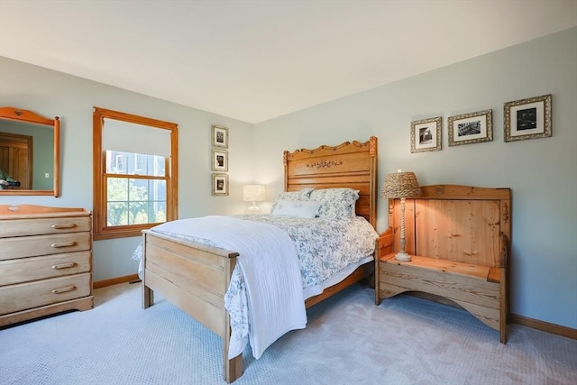 bedroom with light carpet and baseboards