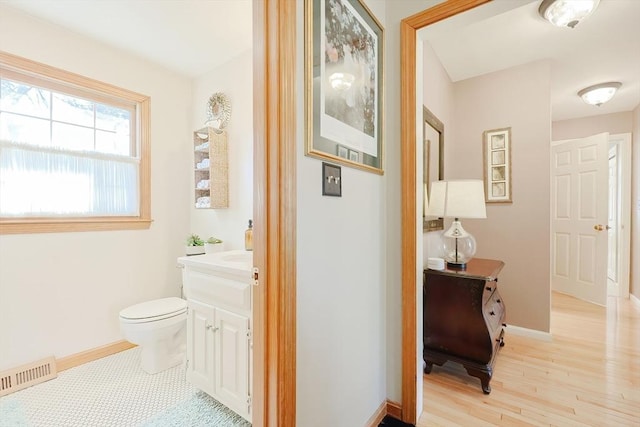 bathroom with visible vents, toilet, vanity, and baseboards