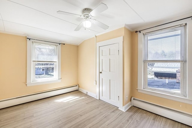 unfurnished bedroom featuring ornamental molding, multiple windows, light wood-style floors, and a baseboard radiator