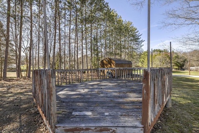 wooden terrace with a storage unit and an outdoor structure