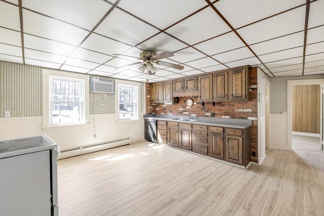 kitchen with a sink, a baseboard heating unit, dishwasher, light wood finished floors, and a ceiling fan