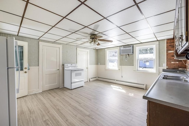 kitchen with a sink, light wood-type flooring, white appliances, an AC wall unit, and a baseboard radiator