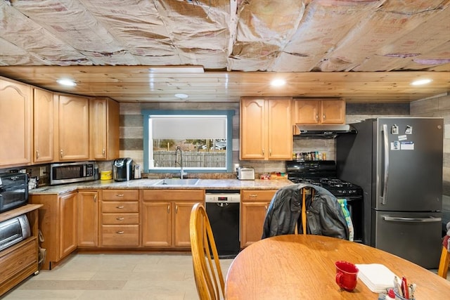 kitchen featuring light stone counters, sink, and black appliances