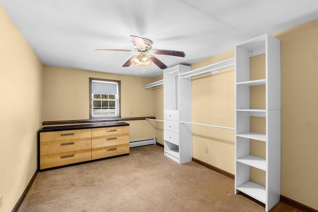 spacious closet featuring ceiling fan, a baseboard radiator, and light carpet