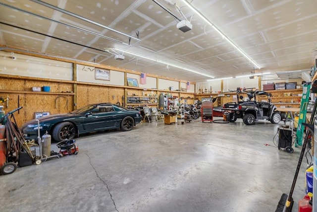 garage with a garage door opener and a workshop area