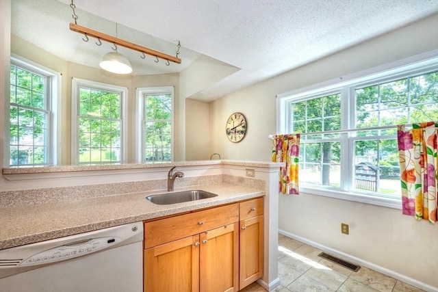 9 Knollwood Ct Unit 9, Burlington, MA 01803 - kitchen with white dishwasher, a sink, light tile patterned floors, light countertops, and baseboards